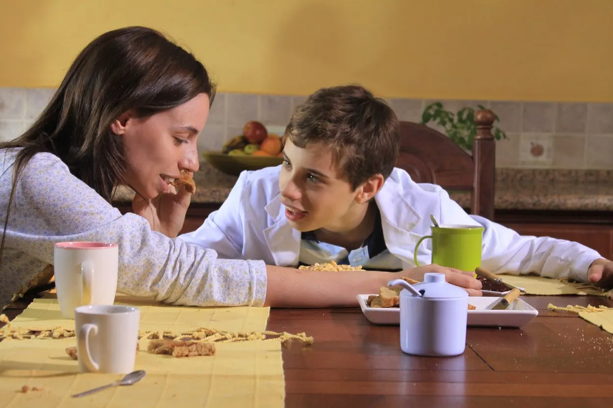 Fotograma de El pozo: conversación junto a una mesa.